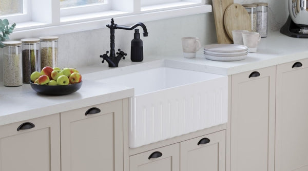 White butler sink with dark tapware and shaker cabinetry