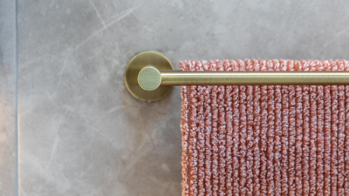 Towel rail installed on a textured bathroom wall